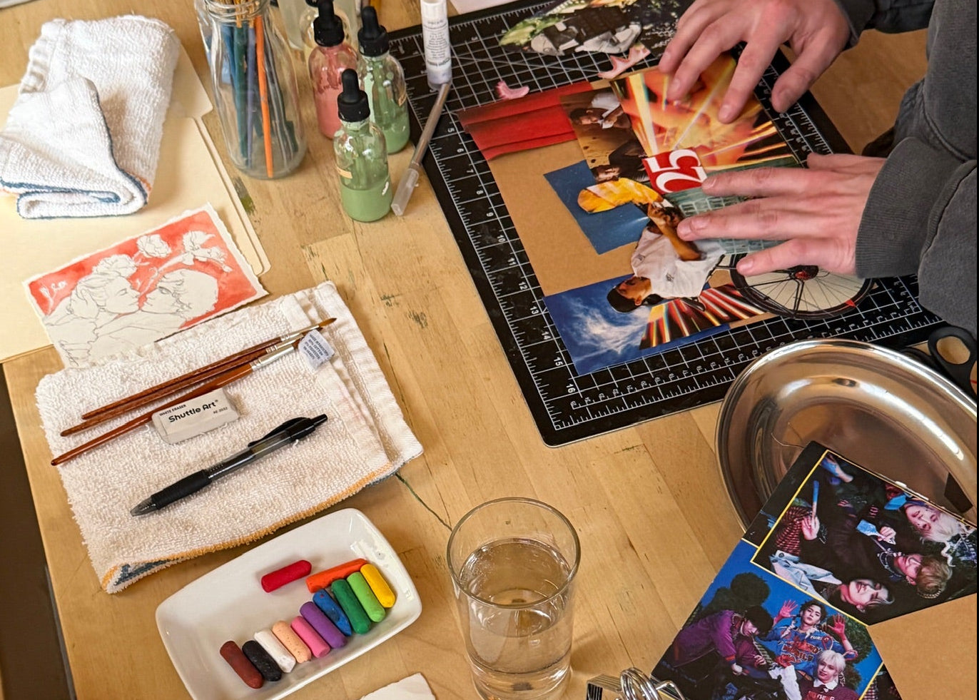 People creating collage and drawing artwork at a table inside Art Café SLC creative studio in Salt Lake City