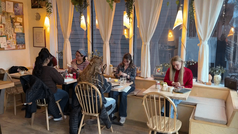 Guests creating art together at tables inside Art Café SLC creative studio in Salt Lake City