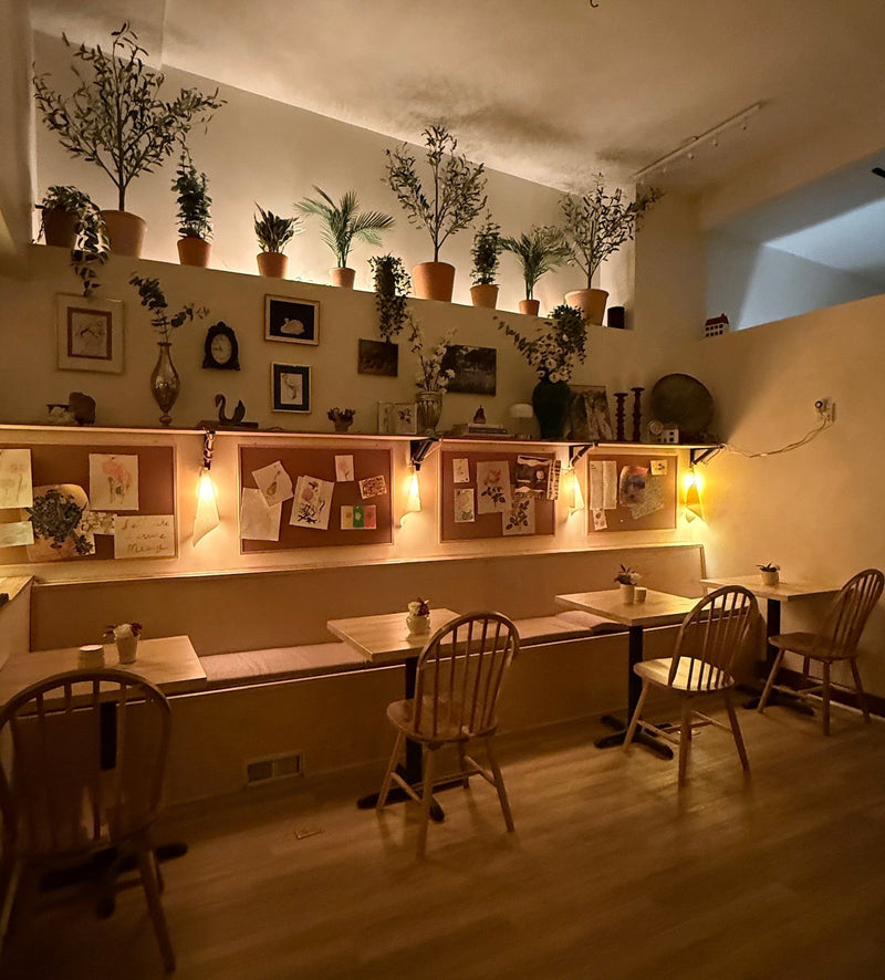Cozy seating and art display wall inside Art Café SLC creative studio in Salt Lake City